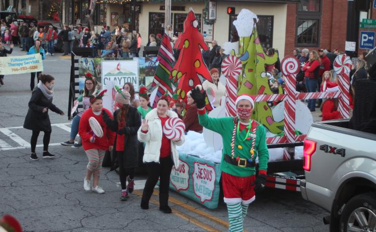 Megan Broome/The Clayton Tribune. Clayton First United Methodist Church was the second place winner in the judging contest for the Clayton Christmas Parade last Saturday with the theme “Jesus is the Sweetest Treat.” Pastor Zack Martin waves at bystanders as the float travels down Main Street.