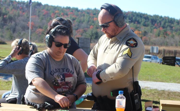 Megan Broome/The Clayton Tribune. Sgt. Riley Owens, right, assists Amber Owens with loading her gun at the Level 3 Firearms Course organized by the Rabun County Sheriff’s Office last weekend.