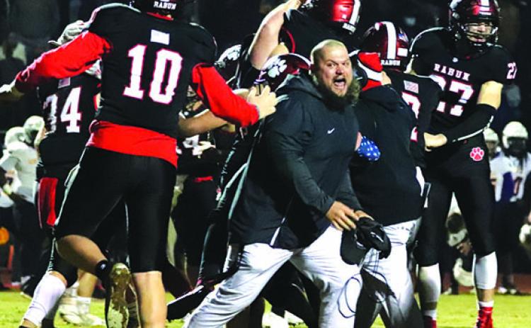 Rabun County Assistant Coach JayJay White joins the celebration after the Wildcats defeated Bleckley 27-24 in overtime last week. The Wildcats need to win one more game Friday night to earn the right to travel to Atlanta and play for a state championship.
