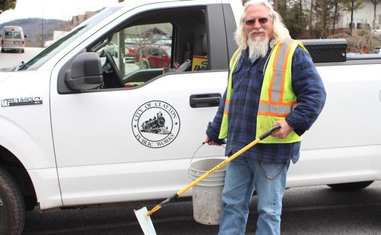 Megan Broome/The Clayton Tribune. Rob Hawsey picks up trash on Main Street in downtown Clayton with a grabber tool on Tuesday. He said that this and a broom are the materials he uses most for his job. Hawsey works for the city of Clayton as a street crew member under the Public Works Division.