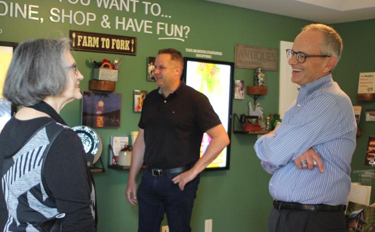 Megan Broome/The Clayton Tribune. Anita Pittman, left, and Todd Webb, COO of ELK Group International, converse with new Chamber President Cliff Bussard at a meet-and-greet at the Rabun County Welcome Center on Monday.