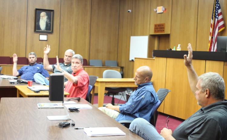 Megan Broome/The Clayton Tribune. Commissioners Will Nichols, left, Kent Woerner, Chairman Greg James, and Tom Garrison, far right, vote to approve a rezoning request from Taywood, LLC to rezone the property 8118 Bridge Creek Rd. from Agricultural to Commercial Business at Tuesday’s commission meeting. Commissioner Scott Crane voted against the motion.