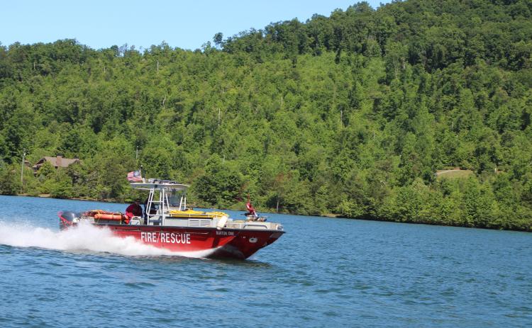 Megan Broome/The Clayton Tribune. The Rabun County Fire Services fire boat led the parade of wooden boats in the annual Lake Burton Wooden Boat Parade on Sunday. The boats set sail from Timpson Cove and made their way to LaPrade’s Marina where members of the public were invited to view the boats.