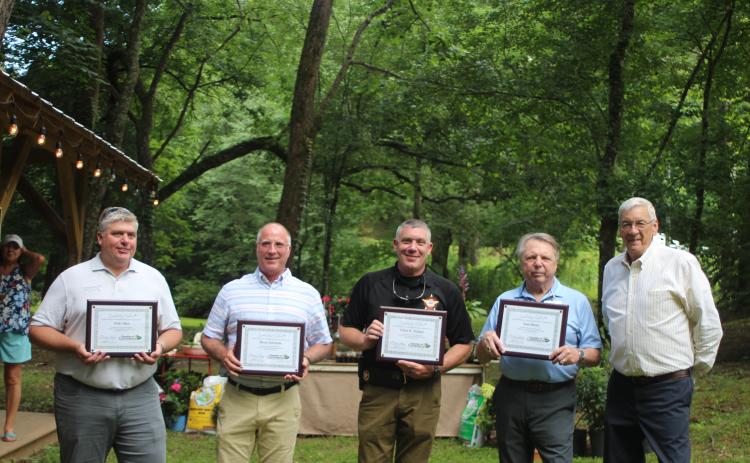 Megan Broome/The Clayton Tribune. Leadership Rabun participants Josh Allen with Habersham EMC, left, Brent Edwards with Georgia Power, Chad Nichols with the Rabun County Sheriff’s Office and Sam Burns of the Rabun County Republican Party are handed their certificates of completion of the program by Tony Allred, former president of the Rabun County Chamber of Commerce at the Chamber’s after-hours event in Lakemont last month.