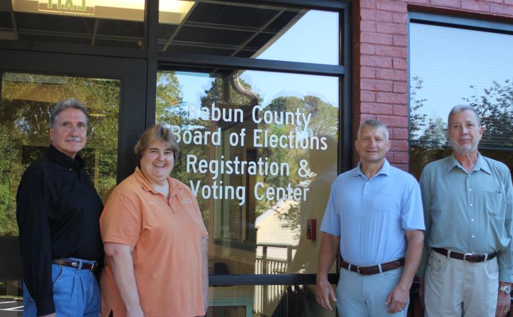 Megan Broome/The Clayton Tribune. Greg James, chairman of the Rabun County Board of Commissioners, left, Tammy Whitmire, Rabun County elections supervisor, Darrin Giles, Rabun County administrator, and Roy Lovell, Rabun County elections board member, pose in front of the new Rabun County Board of Elections Office. The new office is at 184 S. Main St. Suite 102, Clayton (below the health department).