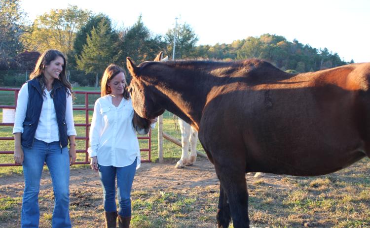 Megan Broome/The Clayton Tribune. Amanda Howard Pileski, licensed psychologist and clinical director of Georgia Mountain Psychological Associates (GMPA), left, and Sunny Volano, licensed professional counselor and director of operations for GMPA, have expanded GMPA services to Londora Valley Farm in Rabun Gap for equine assisted psychotherapy. The goal is for clients to work with horses and help them process and learn to cope with difficult life experiences.
