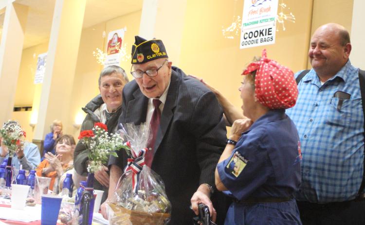 Megan Broome/The Clayton Tribune. Thomas Slowen, left, Carol Cain, dressed as Rosie the Riveter, and Anthony Worley congratulate Korean War Army Veteran Lloyd Hunter, as he is honored at the Veterans Appreciation Dinner held at the Rabun County Civic Center last Thursday. Hunter is 93-years-old and has owned Hunter Funeral Home since 1969. He is part of American Legion Post 220. He also worked in the Coroner’s Office for 52 years.