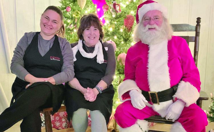 Photo courtesy of Jenifer Kulow/The Clayton Tribune. Dena Crane and Susan Kulow pose with Santa Claus at the Christmas Village of Lights event sponsored by FAITH last weekend. The event continues this weekend. Donations at the event benefit abuse victims.