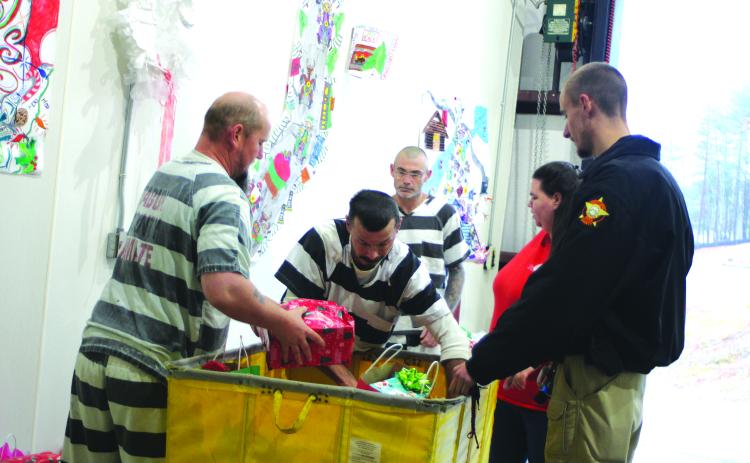 Megan Broome/The Clayton Tribune. abun County Detention Center inmates Alvin Michael Watkins, Shannon Lee Watkins, and Shanan Glenn Britt, along with Transport Officer Steven Barnes and TAC Heather Abernathy  help pass out gifts to children of inmates on Dec. 18. The detention center partnered with Tabernacle Baptist Church to provide Christmas gifts that are from the inmates to their children in time for Christmas.