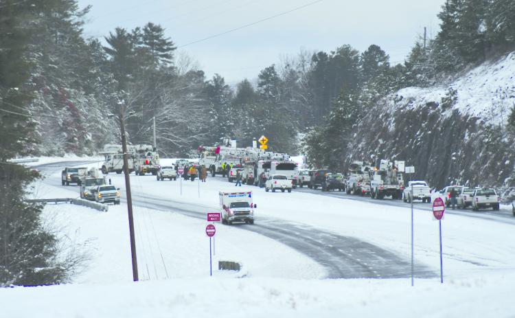 Enoch Autry/The Clayton Tribune. Utility crews work to clear Highway 441 North Monday morning outside the city limits of Clayton.