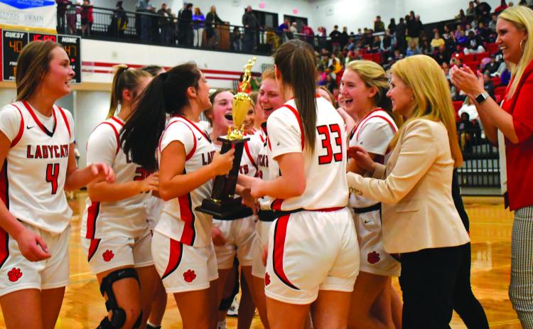 Enoch Autry/The Clayton Tribune. The Rabun County Ladycats celebrate with their region championship trophy they won on Feb. 18 with their defeat of Elbert County. The girls -- like the boys -- now are in the state AA tournament.