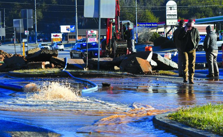 Enoch Autry/The Clayton Tribune. Water pours out into the parking lot from the Feb. 10 leak.
