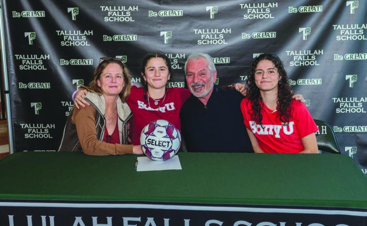 E. Lane Gresham/Tallulah Falls School. Tallulah Falls soccer player Honora Kahwach hugs her mother Kim Newberry and father Joseph Kahwach at the Feb. 9 letter of intent signing with Barry University. Sister Chloe Kahwach is seated on the far right. The senior has been a consistent leader for the Lady Indians.