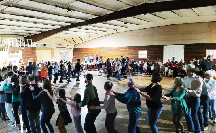 Megan Broome/The Clayton Tribune. Locals and people in neighboring communities came out for the soft opening of the Mountain City Playhouse on March 12. Attendees do the "bunny hop" among a crowd that was standing room only at the venue.