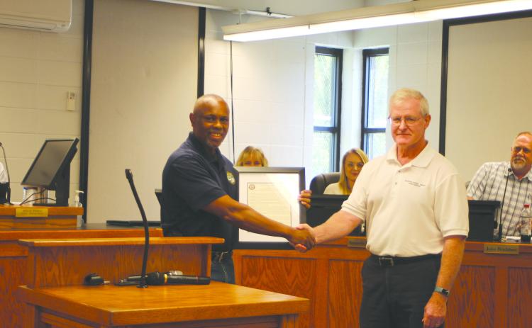 Megan Broome/The Clayton Tribune. Keith Owens, City of Clayton Wastewater Treatment Plant supervisor, left, accepts a Georgia Rural Water Association award for the hard work he and coworker Clint Harbin do for the city, presented by Dennis Brown, energy efficiency and plant organization specialist for the Georgia Rural Water Association.  The award was given after consulting with Brown on how to implement operating strategies at the Wastewater Treatment Plant that would result in energy-saving measures.
