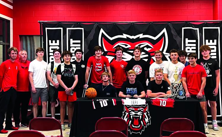 Submitted photo. Surrounded by his teammates, Rabun County senior Gus Hood (seated, center) signs with Covenant College after a solid high school career as a point guard. Hood averaged 13 points a game as a senior.