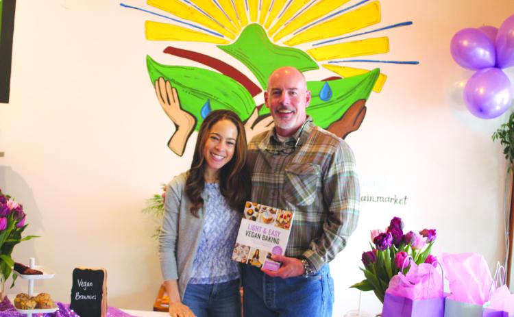 Megan Broome/The Clayton Tribune. Jillian Glenn, who has the blog “Peanut Butter & Jilly,” poses with her father Roger Glenn at her book signing for her second title “Light & Easy Vegan Baking,” held at the Holistic Mountain Market in Clayton on April 16.  Her first book “Easy Low Cal Vegan Eats” has recipes for every meal of the day.