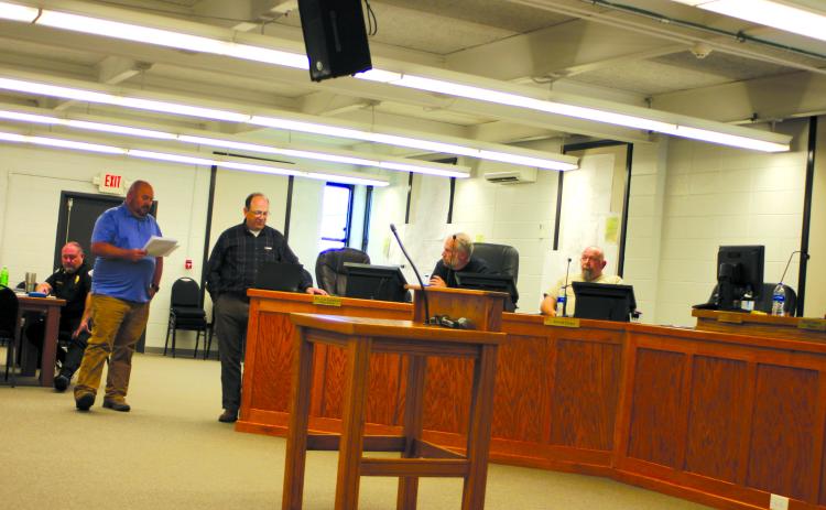 Megan Broome/The Clayton Tribune. Jason Waldroup, public works director for the city of Clayton, and Eric Neese, engineer for the city of Clayton, talk to Clayton council members at a council meeting earlier this year about the need to increase water rates for Clayton water customers. Council members unanimously approved an increase of 20 percent, which Walroup said increases customer monthly bills $5-$10.