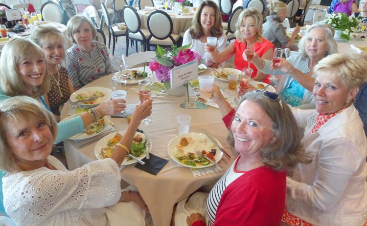 Jenifer Kulow/The Clayton Tribune. Community members toast to spending time together at the F.A.I.T.H. Fairways and Fashions event.