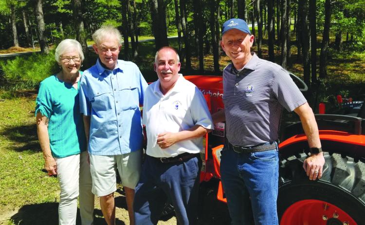Submitted photo. Event organizer Kathy Booker, donor Steve Raebel, Victory Home Director Mark Beach, and donor Mike Hammer stand beside the new tractor that was purchased for Victory Home.