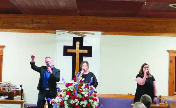 Megan Broome/The Clayton Tribune. Echoes of Mercy from Anderson, S.C., made up of Brian, Laura and Ashley Latham, sing worship music as the guest musicians for Bethel Baptist Church’s 130th Anniversary celebration July 17.