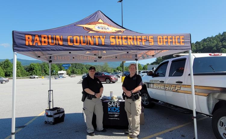 Megan Broome/The Clayton Tribune. Deputies Lisa Thompson, coordinator for Safe Kids Rabun County, and Ana Contreras conduct Car Seat Safety Checks and check seats for expiration, safety recalls, proper fit and proper installation. The technicians also educated the public about vehicle safety during the event at Walmart July 23.