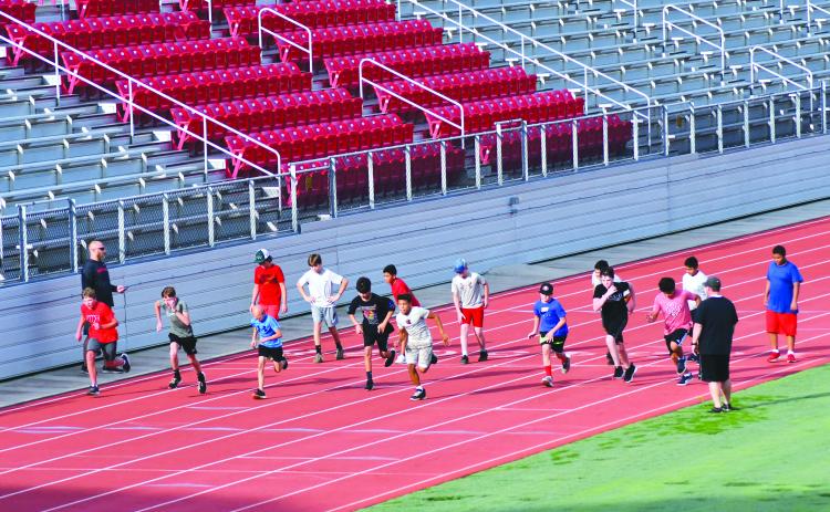 Enoch Autry/The Clayton Tribune. With coaches watching, student-athletes get in some early morning sprints at Rabun County High School.