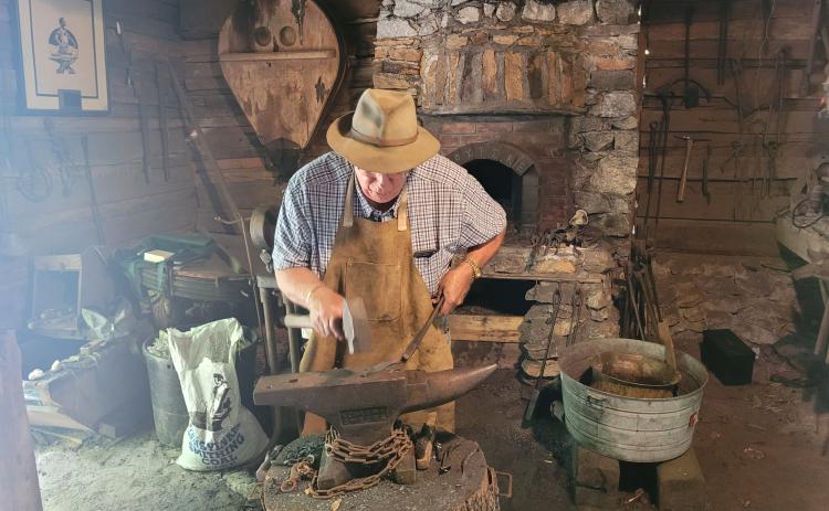 Megan Broome/The Clayton Tribune. Joe Williams demonstrates blacksmithing at the Foxfire Museum Heritage Days event in Mountain City July 8 and 9.