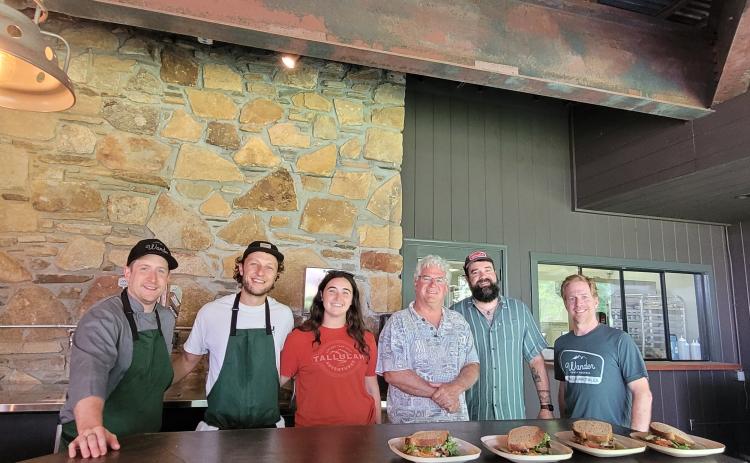 Megan Broome/The Clayton Tribune. Chef Ryne Brown, General Manager of Food Service for Tallulah Adventures, left; Kyle Jerome, Food Service Coordinator for Tallulah Adventures; Spencer Turk, operations and events manager for Tallulah Adventures; Bill Turk, owner of Tallulah Adventures; Josh Brown-co-owner of Wander North Georgia; and Jake Scott-co-owner of Wander North Georgia open Tallulah Adventures and the second location of Wander North Georgia to members of the public.