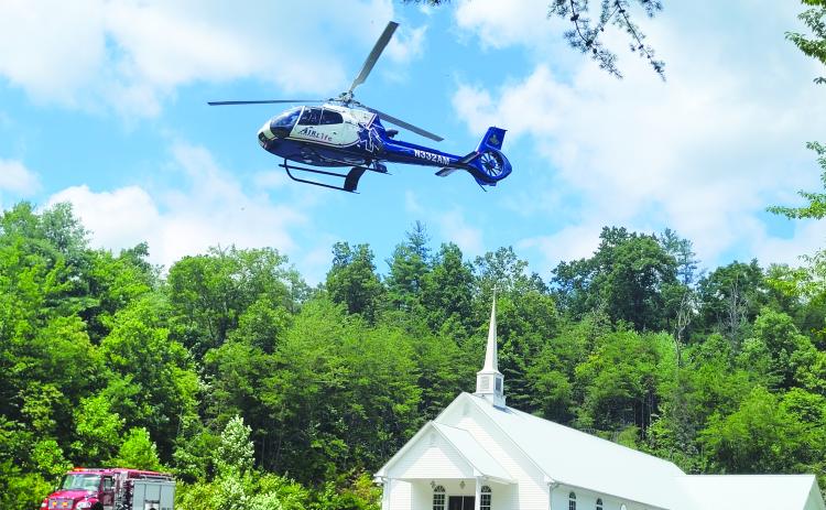 Megan Broome/The Clayton Tribune. Emergency personnel work the LZ site located at Pleasant Hill Missionary Baptist Church as the patient is transported by AIRLife following a single motorcycle crash on Warwoman Road Aug. 13.