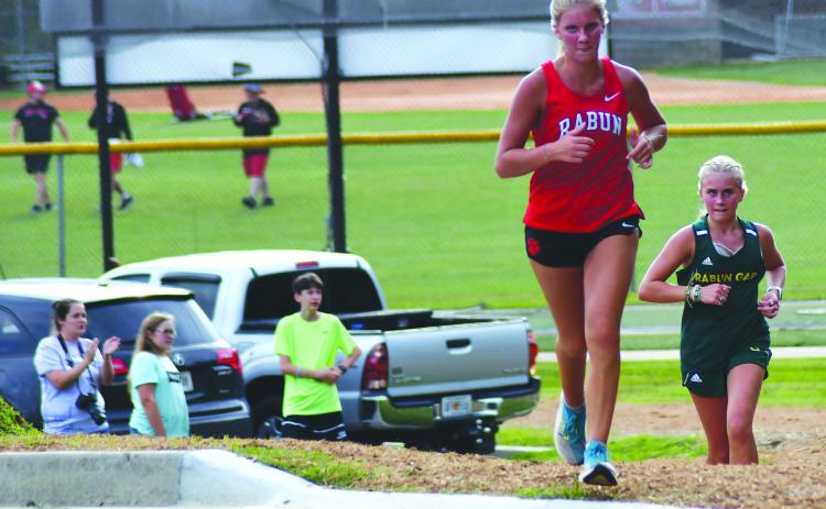 Enoch Autry/The Clayton Tribune. RCHS’s Molly Jo Wright and Rabun Gap’s Bailey Brackett head toward the stadium at the unveiling of the new course Aug. 18. Wright claimed second and Brackett took third.