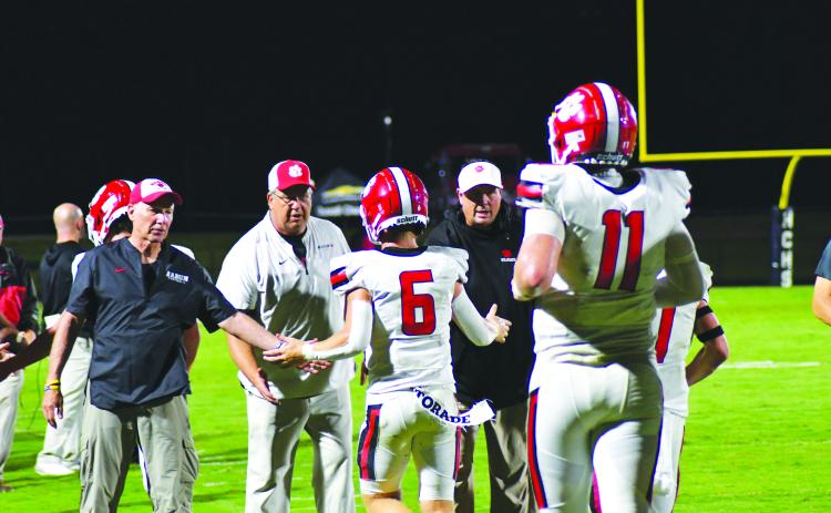Enoch Autry/The Clayton Tribune. Senior Jaden Gibson (6) receives congratulations from the Wildcat coaching staff after catching the second of four touchdown from senior quarterback Keegan Stover (11) on Aug. 19 against Haralson County.