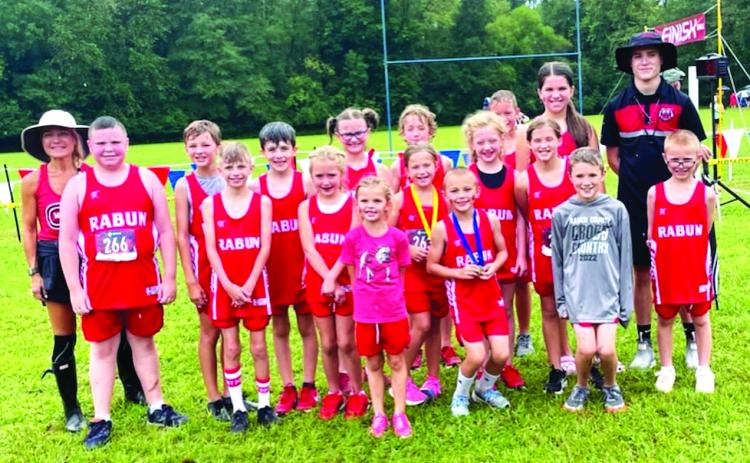Courtesy of Ed Eidson. Head Coach Ed Eidson (right) and assistant head coach Holly Henry-Perry (left) pose with their team who all notched personal bests.