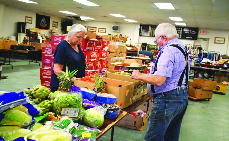 Megan Broome/The Clayton Tribune. Maryjane Webb Phillips and Carl Green volunteer at one of the Food Distributions held at the American Legion Post 220 last month. The food distribution is held every Thursday from noon-6 p.m.