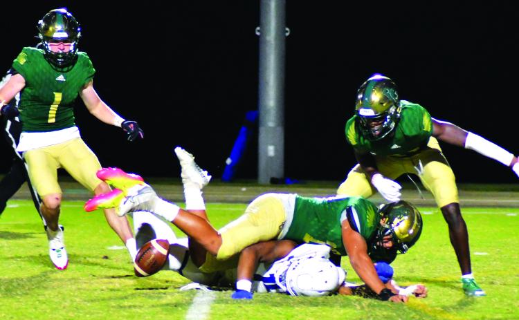 Enoch Autry/The Clayton Tribune. RGNS junior Huseyin Simsir (center) knocks the ball away from Charlotte Christian punt returner Micah Gilbert. Simsir collected the ball and then the Eagles added a field goal to push the score to 24-10.