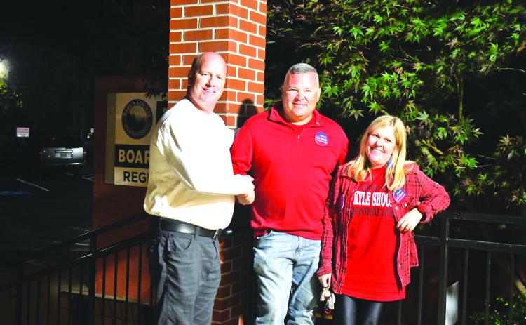 Megan Broome/The Clayton Tribune. Candidates for Magistrate Judge James Blalock and Kyle Shook shake hands outside the Rabun County Board of Elections Office Tuesday evening as they await election results. Also pictured is Sonya Shook.