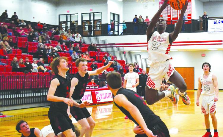Luke Morey/The Clayton Tribune. With teammates junior Cooper Welch (14) and senior Jayton Henry (20) in the background, junior Willie Goodwyn goes up for a layup in the fourth quarter of Saturday’s game against Franklin, N.C. Goodwyn scored 12 points to help the Wildcats to a narrow 43-40 victory.