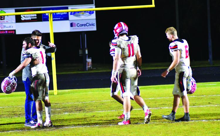 Enoch Autry/The Clayton Tribune. Rabun County High School Principal Justin Spillers gives Nic Baloga a hug as fellow seniors Lang Windham, Keegan Stover, and Jaden Gibson walk off the field in Swainsboro following the Wildcats’ 35-10 Nov. 25 Class A Division I state quarterfinal loss to the Tigers. Each of these seniors were statewide leaders in various individual categories.