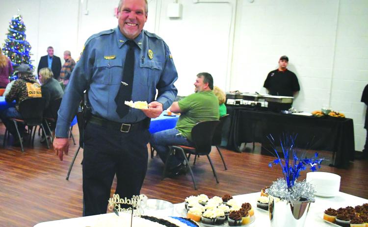 Megan Broome/The Clayton Tribune. Mountain City Police Chief Tom Garrison is all smiles as he cuts his cake at his retirement reception from the City of Mountain City on Dec. 30, 2022. Garrison retires after serving as a law enforcement officer for 28 years and Mountain City Police Chief for 18 years.