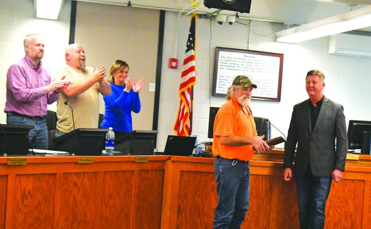 Megan Broome/The Clayton Tribune. Clayton Mayor Kurt Cannon, right, presents Streets Department worker Everiest Turpin with a plaque thanking him for his years of service to the city after he announced his retirement. Turpin received a standing ovation from council members and attendees, and pictured are council members Woody Blalock and David Cross and City Manager Trudy Crunkleton congratulate Turpin during his 18th year of service.