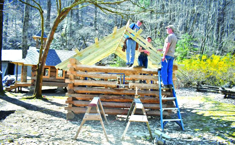 Megan Broome/The Clayton Tribune. Volunteer Tommy Thompson; Kami Ahrens, curator and director of education for Foxfire; and Barry Stiles, museum director, work to build the Ingram Mule Barn as the newest addition to the Children’s Village at the Foxfire Museum and Heritage Center. The scaled-down village for kids, modeled after existing buildings, is being built by hand using traditional tools like those used over 100 years ago.