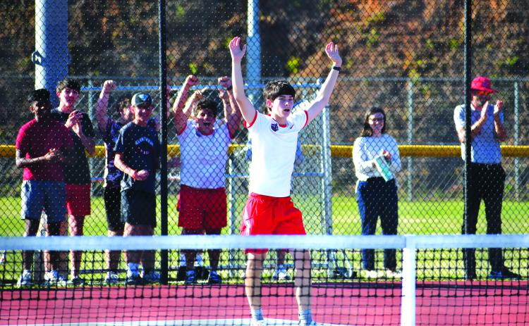 Luke Morey/The Clayton Tribune. With his teammates and classmates cheering in the background, RCHS freshman singles tennis player Brady Darnell raises his arms in victory for his three-set Tuesday win that propelled the Wildcats into the Sweet Sixteen.