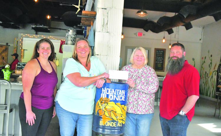 Megan Broome/The Clayton Tribune. Nancy Gribble with Ferst Readers of Rabun County accepts a donation check for $3,075 from nonprofit night held at Currahee Brewing Company on April 6. Pictured are Ara Joyce, Hillary Marshall, Gribble and Scott Mazarky.