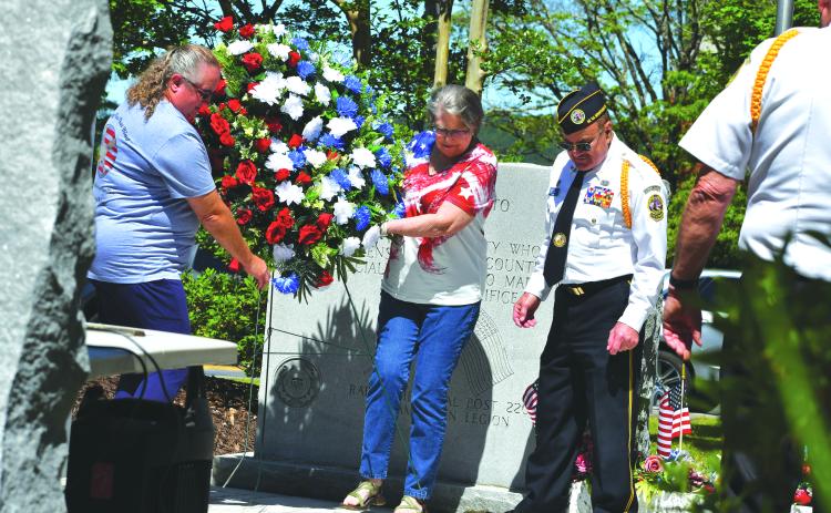Megan Broome/The Clayton Tribune. Pam Wheeler, founder of the organization Creating Ties That Bind: For Soldiers and Families Wounded By Loss; and Karen Trombley, state coordinator for Quilts of Valor Foundation, place the wreath to honor soldiers who passed at the Memorial Day Ceremony held at the Rabun County Courthouse Monday. Also pictured are Chaplain Dr. Kenneth Franklin, DAV. CH. 15 and SVCDR. DAV. Ch. 15 Doug Wayne in the foreground.