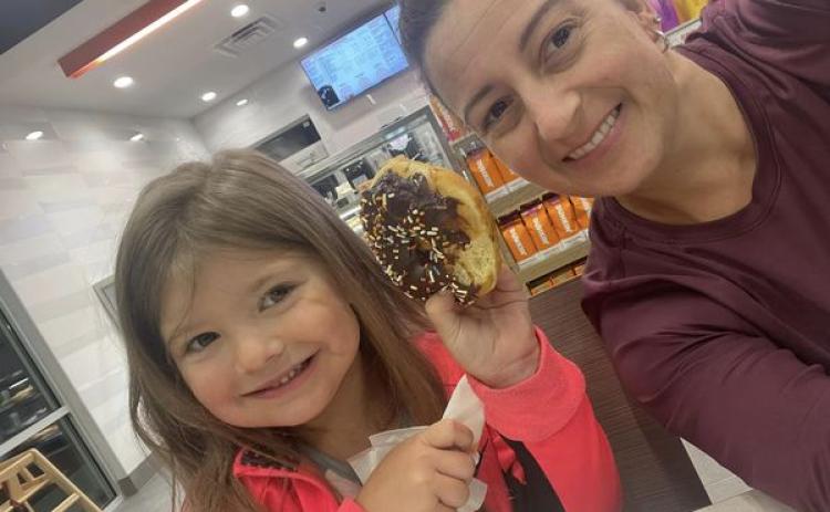 Submitted. Locals Amber Owens and 5-year-old Rylee Owens are the first customers to enjoy doughnuts just before 5 a.m. at the new Dunkin’ Donuts in Clayton on opening day Thursday, July 13.