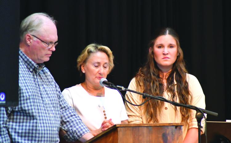 Enoch Autry/The Clayton Tribune. Breck Patterson, Lisa Patterson and their daughter Cylvie stand before the audience at the Rabun County Civic Center to talk about the life of Chan Patterson, a firefighter who died in a boating accident in June 2021 on Lake Tugalo in Rabun County. Search and Rescue consoled the Patterson family. Below:  Sheriff Chad Nichols sits with his 6-year-old son Chatham at the banquet.