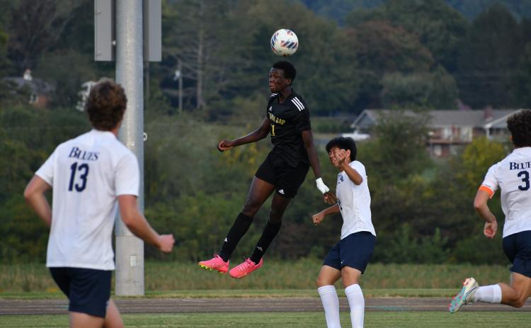 Wade Cheek/The Clayton Tribune. Eagle senior forward Theo Ochieng soars above Blues defenders for a header against region opponent Asheville School. RGNS is currently the No. 2 team in the NCISAA 4A division.