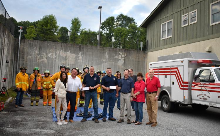 Megan Horn/The Clayton Tribune.  Pictured are Debi Bock and David Bock with Highlands Festival, Inc.; Chief Ken Sigler; Assistant Chief Jamie Chastain; Jeff Marlow and Debra Marlow with Windfield Development; Steve Mehder with with Highlands Festival, Inc.; and firefighters from Sky Valley-Scaly Mountain Volunteer Fire & Rescue. Not pictured are Nancy and Rebecca Maddox with Windfield Development.
