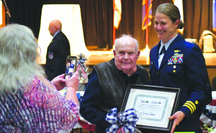 Enoch Autry/The Clayton Tribune. Kathy Causey takes a photograph of her father Eldrid Causey with Commander Sarah Ernst at the conclusion of the 24th Annual Veterans Appreciation Dinner on Nov. 9 at the Rabun County Civic Center. Ernst told the audience about 99-year-old Causey who served in WWII and was the oldest veteran at the event.