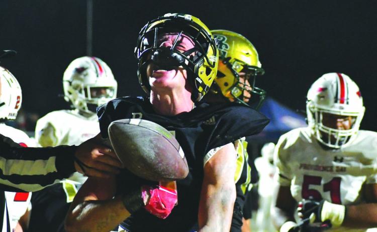 Wade Cheek/The Clayton Tribune. Rabun Gap’s Trey Horne, a Georgia Tech commit, vocally reacts after scoring a touchdown in the NCISAA state championship game as the referee reaches in grasp Horne’s arm with the ball. The Eagles fell 34-27 in the contest to Providence Day.